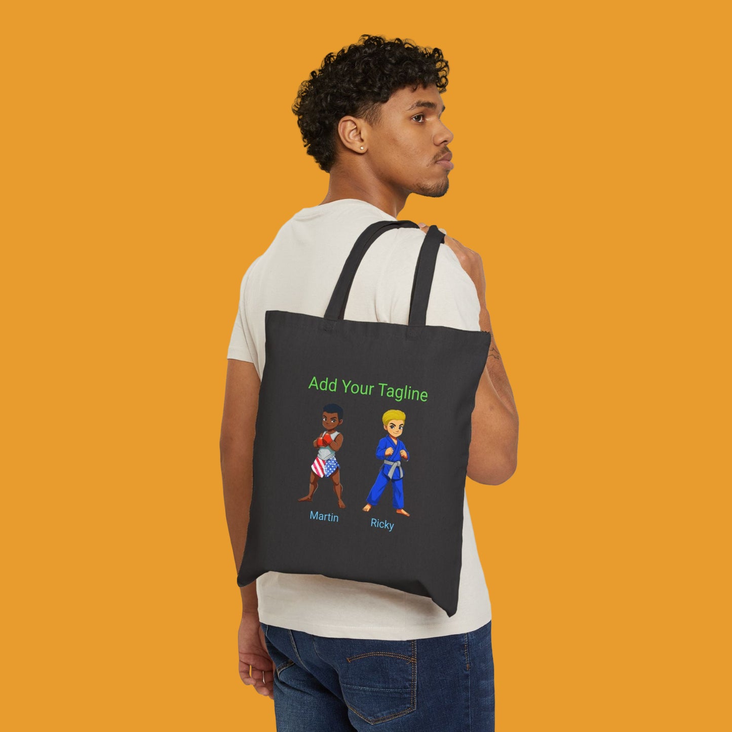 Person holding a black tote bag with customizable text and cartoon characters on a black background